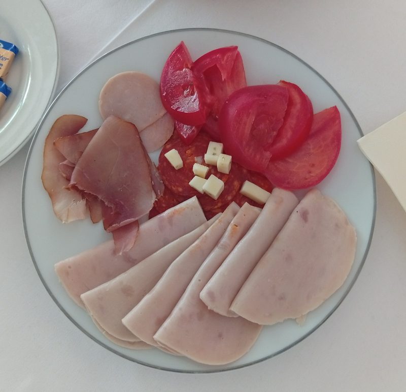 Bosnian cold cuts platter — šunka, sudžuk, mortadela and fresh tomato, traditional charcuterie from the region