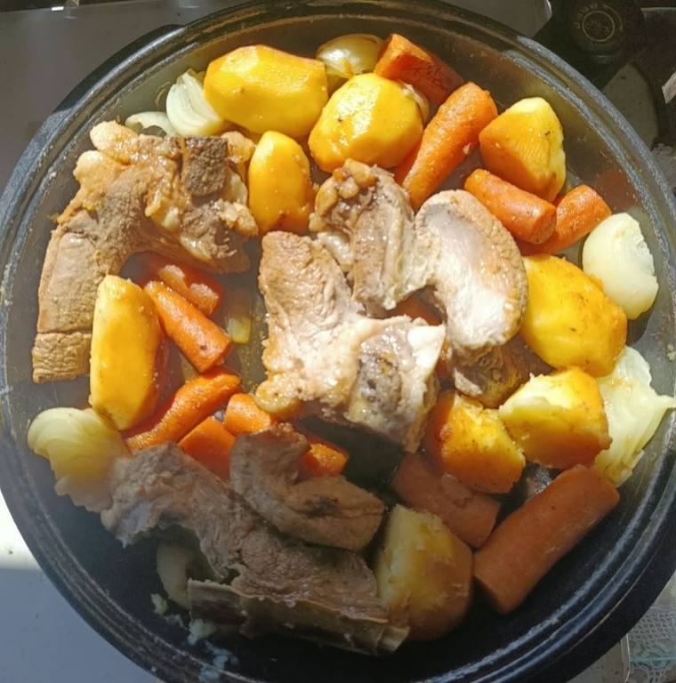 Slow-cooked pork and beef with potatoes, carrots and onion in a black pot — Bosnian home cooking near Banja Luka
